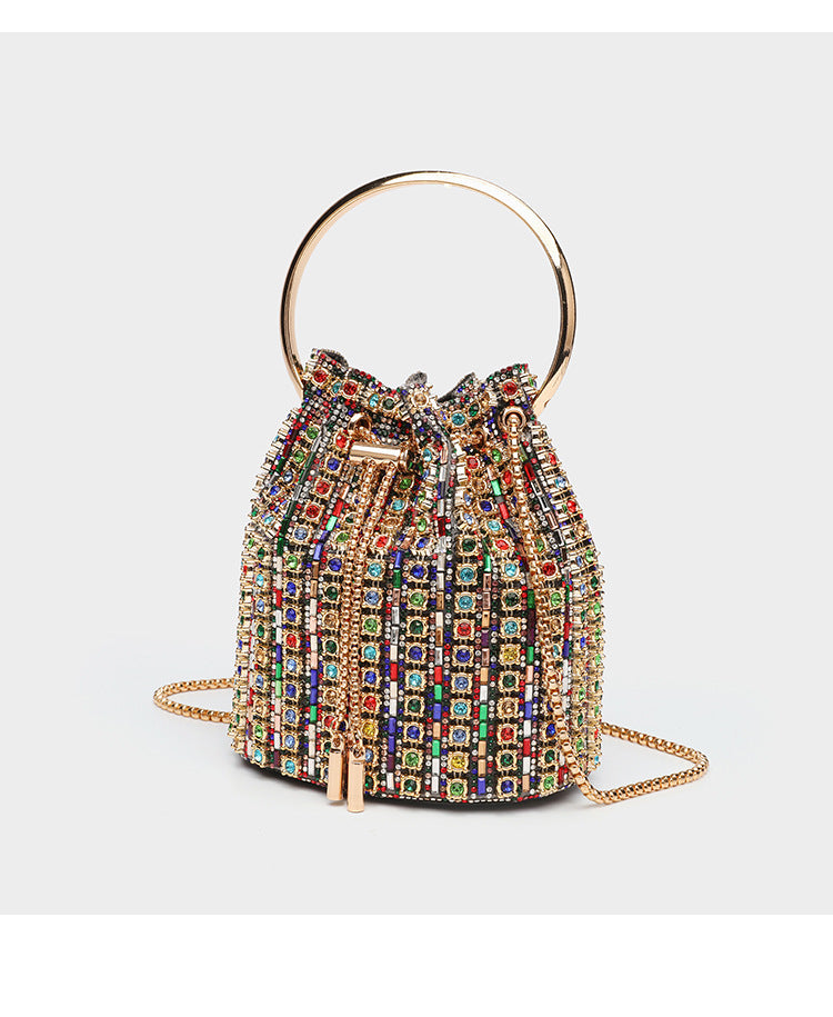 Mini crystal rhinestone bucket bag with circular ring top handle, drawstring closure, and silver chain shoulder strap, detail