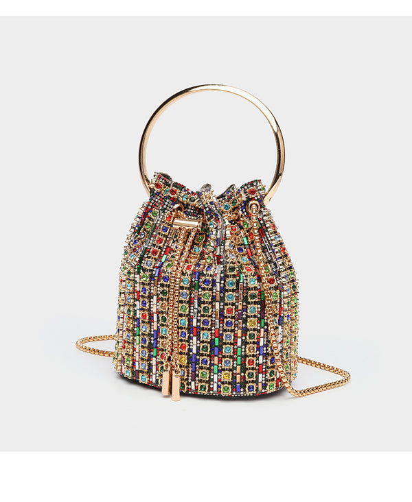Mini crystal rhinestone bucket bag with circular ring top handle, drawstring closure, and silver chain shoulder strap, detail