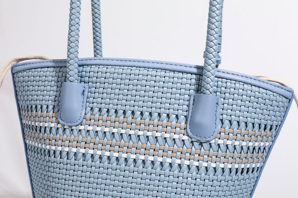 Light blue open-weave woven bucket tote bag with long braided shoulder straps, drawstring side ties, and attached mini pouch
