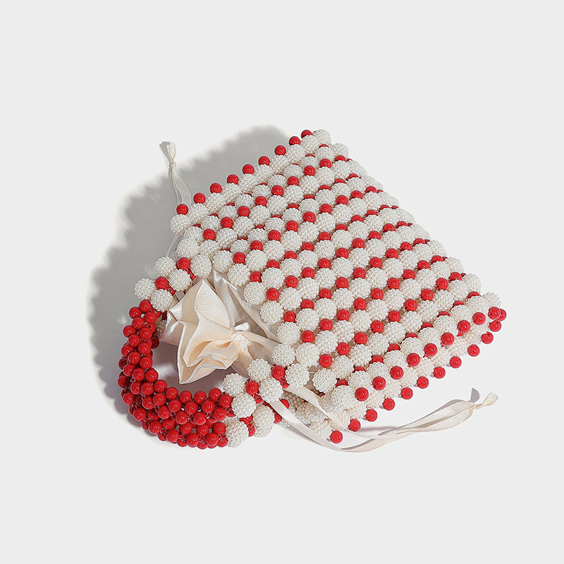 Small boxy pearl-bead mini top-handle bag with silver metallic bead accents, satin floral detail, and long beaded shoulder