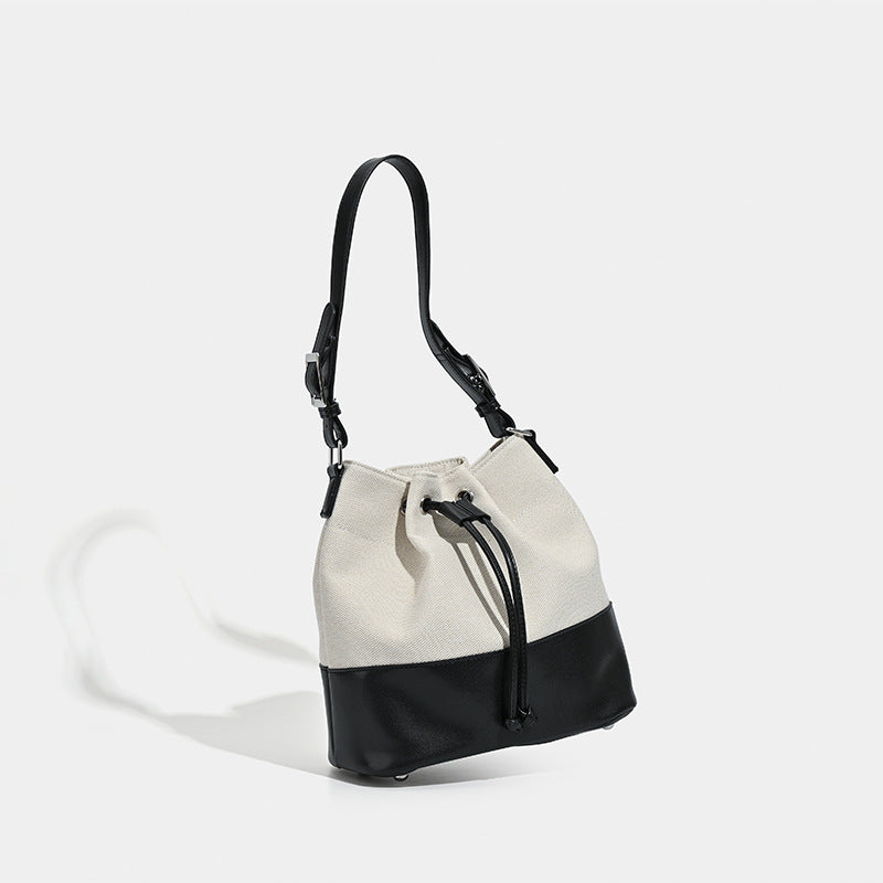 Beigefarbene Bucket-Bag aus Canvas mit Kordelzug, kontrastierendem Unterteil in Lederoptik und verstellbarem Schulterriemen, Detailansicht 3