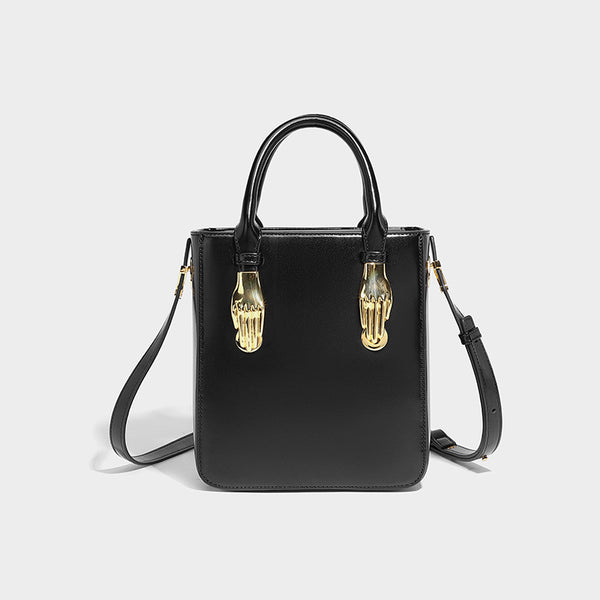 Kleine, strukturierte, kastenförmige Henkeltasche mit goldfarbenem, handförmigem Beschlag in schwarzer Lederoptik und abnehmbarem, Detailansicht