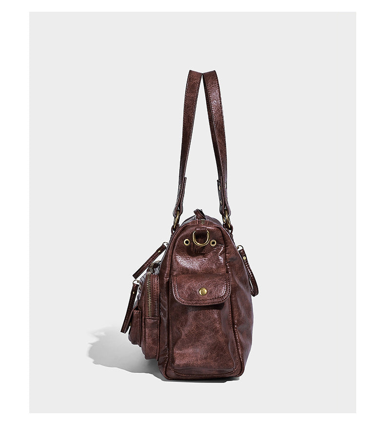 Distressed leather-look vintage satchel shoulder bag with multiple front zip pockets, dual top handles, and brass-tone