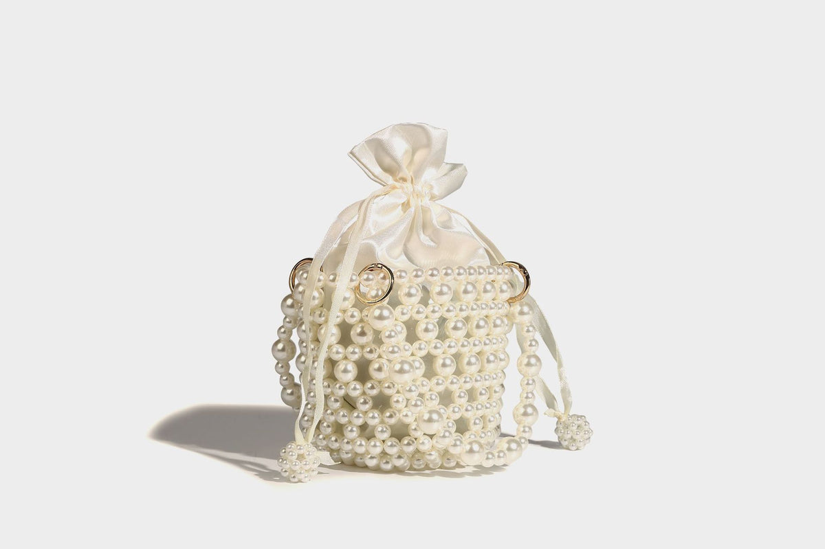 Elfenbeinfarbene Mini-Bucket-Bag aus Kunstperlen mit Satin-Innenbereich und Zugband, goldfarbenen Ringbeschlägen und gewölbtem Perlenhenkel an der Oberseite