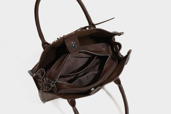 Structured leopard-print tote bag with glossy satin-like finish, dual rounded top handles, silver buckle-and-ring front