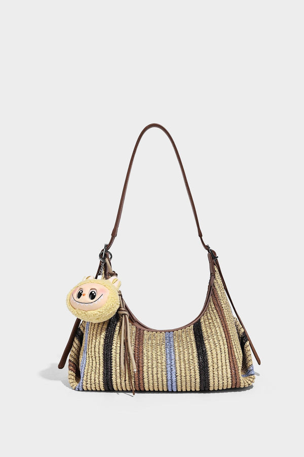 Slouchy woven straw hobo shoulder bag with beige, black, brown, and blue vertical stripes and brown leather-look trim, detail