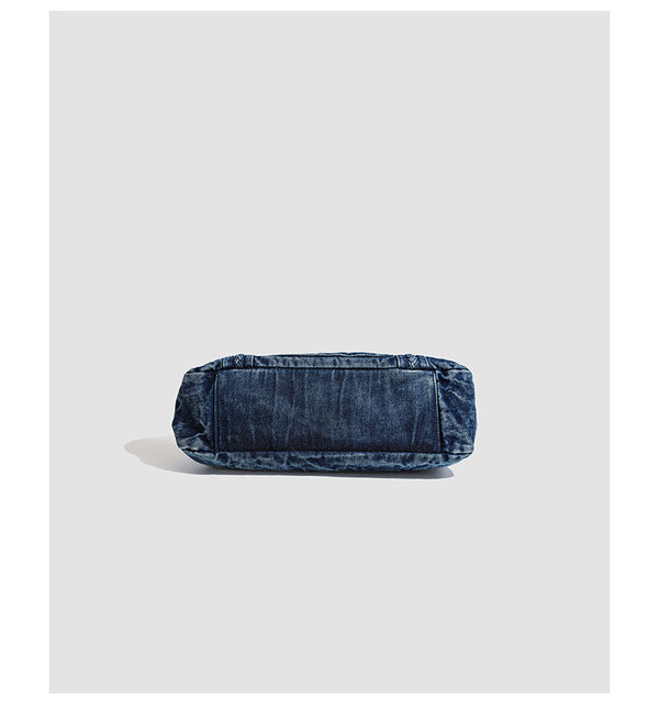 Large washed blue denim-look shoulder bag with gold-tone rings and rivets, top zip closure, front zip pocket, and adjustable