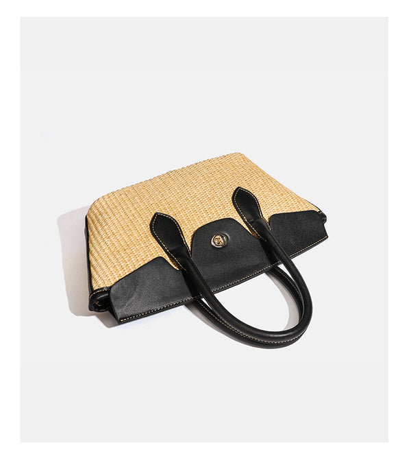 Structured tan woven straw tote bag with black leather-look trim, twin rounded top handles, gold-tone turn-lock front flap