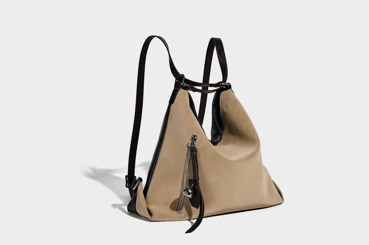 Slouchy hobo tote bag with matte leather-look finish, triangular silhouette, front zip pocket, and adjustable shoulder strap