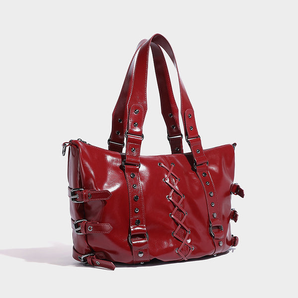 Glänzende Shopper-Tasche in Lederoptik mit geschnürtem Korsett-Element auf der Vorderseite, Nietenbeschlägen und seitlichen Riemen mit Schnallen, Vorderansicht