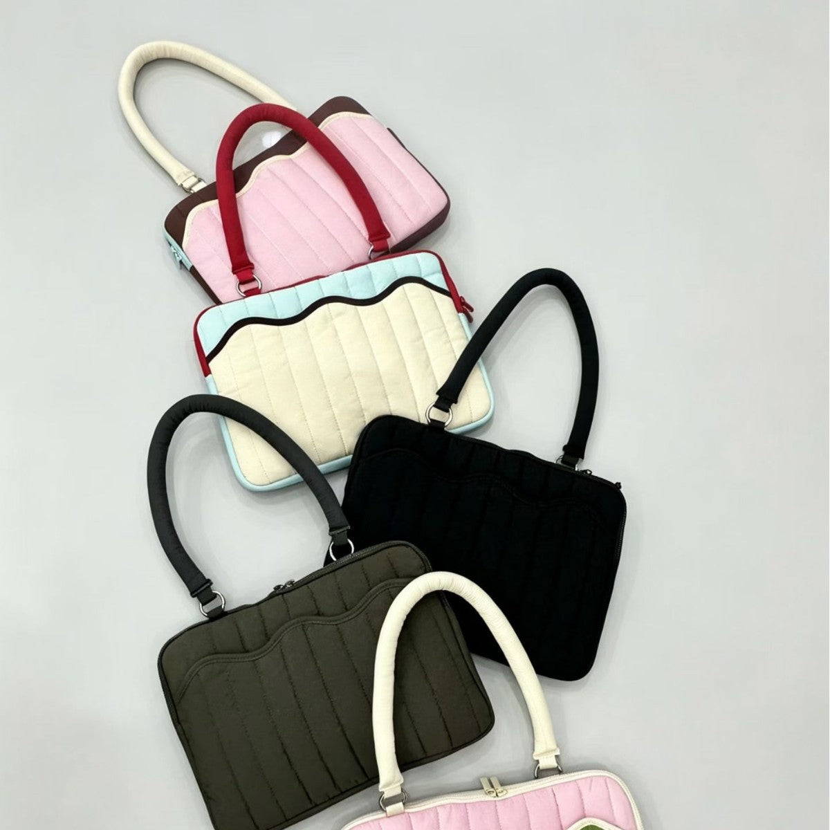 Quilted colorblock handbag with wavy scalloped front panel, padded arched top handles, and dual zip closure, detail view 4