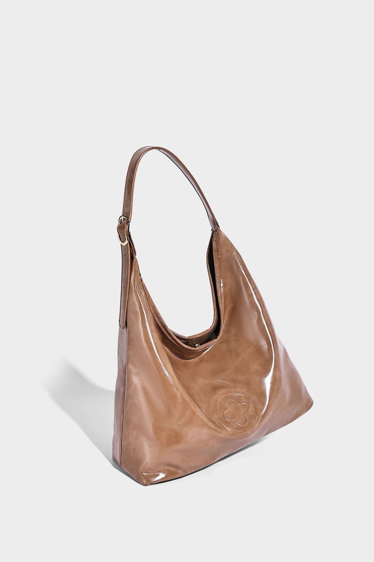 Glossy slouchy hobo shoulder bag with adjustable strap and embossed floral emblem, detail view 15