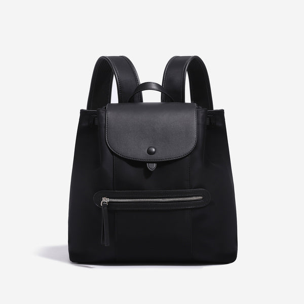 Large flap-top nylon backpack with leather-look trim, snap closure, front zip pocket, and padded shoulder straps, detail view