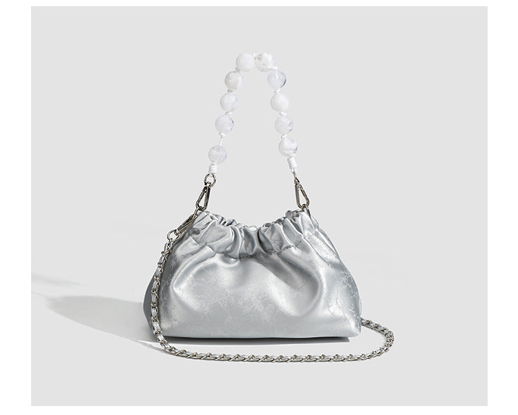 Small ruched drawstring pouch bag with pearl-bead handle and silver-tone chain strap, detail view 10