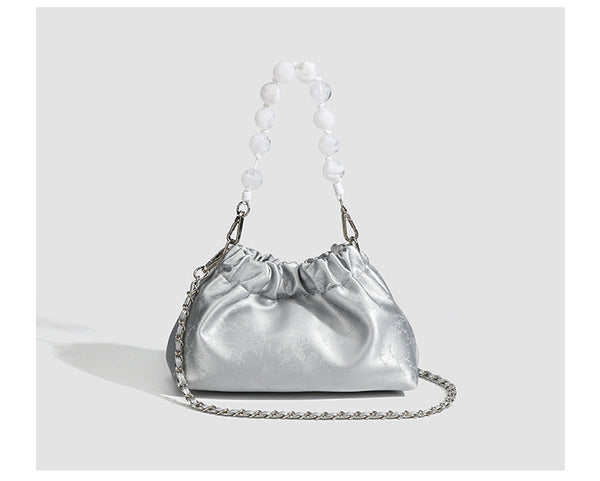 Small ruched drawstring pouch bag with pearl-bead handle and silver-tone chain strap, detail view 10