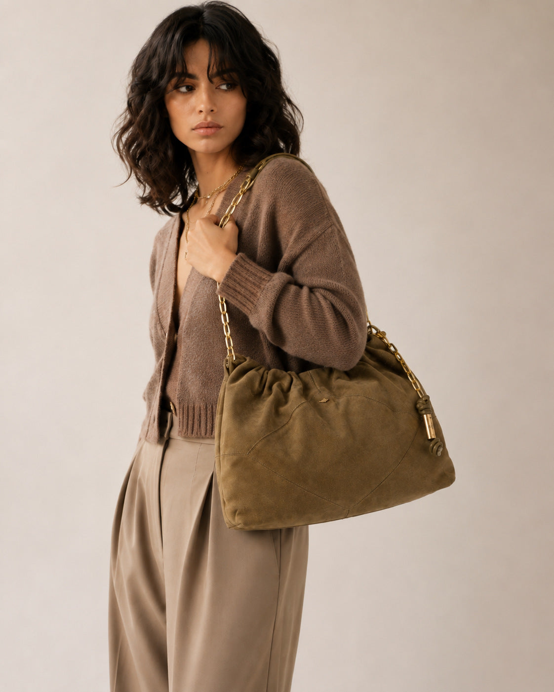 Slouchy suede-look shoulder bag with gathered top, angular stitched paneling, and chunky gold-tone chain strap, detail view