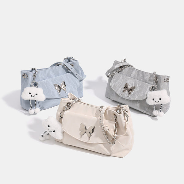 Soft rectangular glossy leather-look shoulder bag with silver chain strap, butterfly ornament on front flap pocket, and