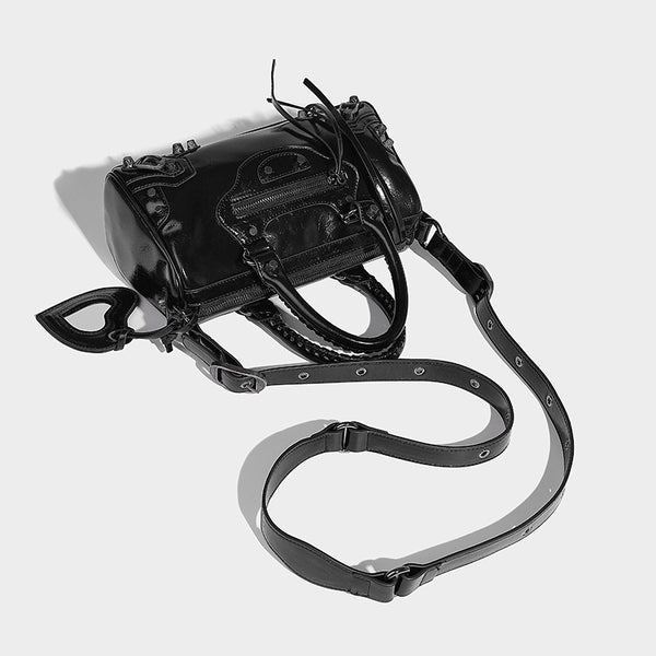 Glossy studded mini satchel bag with braided top handles, front zip pocket, heart charm, and detachable crossbody strap