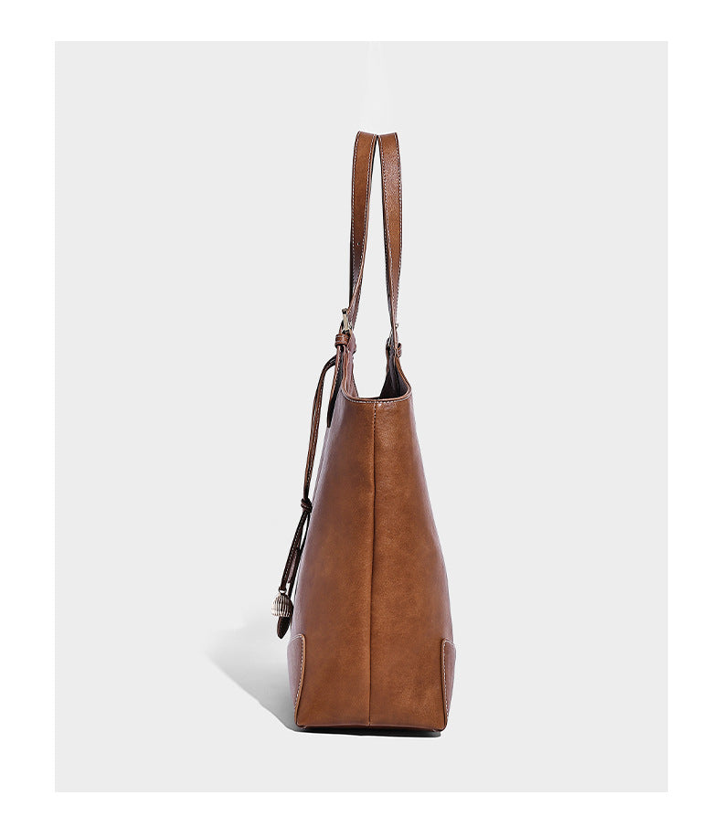 Große, strukturierte Schultertasche im Tote-Stil in Braun und Lederoptik mit langen Doppelriemen, Schnallenbeschlägen, Quasten-Anhänger und geschwungener