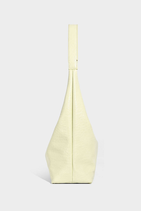 Slouchy hobo shoulder bag in pale yellow glossy pebbled leather-look finish with single shoulder strap and detachable front