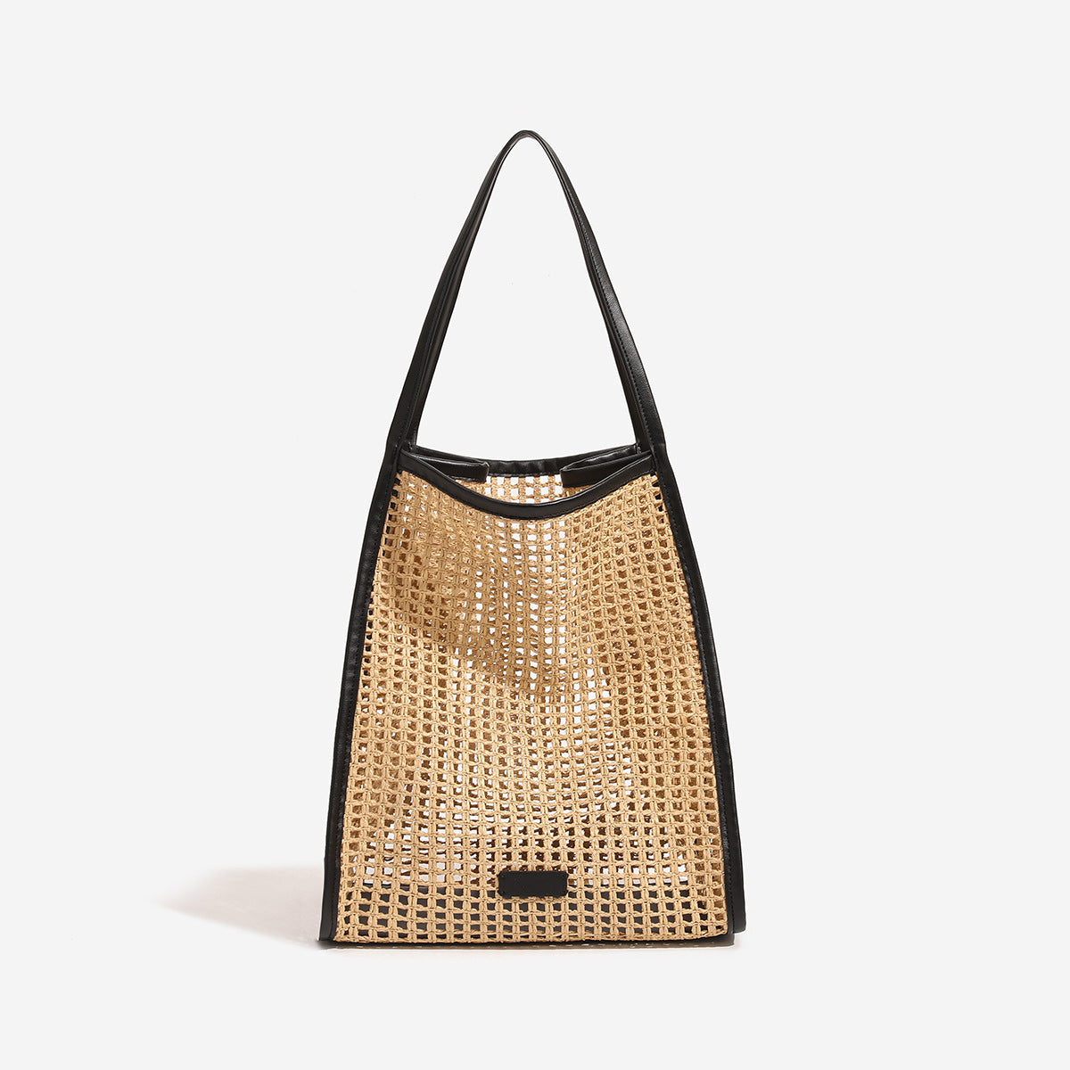 Tan open-weave raffia tote bag with black leather-look trim and long black shoulder straps, trapezoid silhouette, detail view