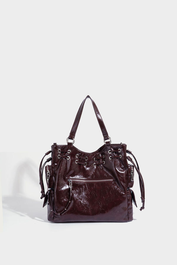 Glossy crinkled leather-look tote bag with silver grommet lace-up front detail, dual top handles, and detachable shoulder