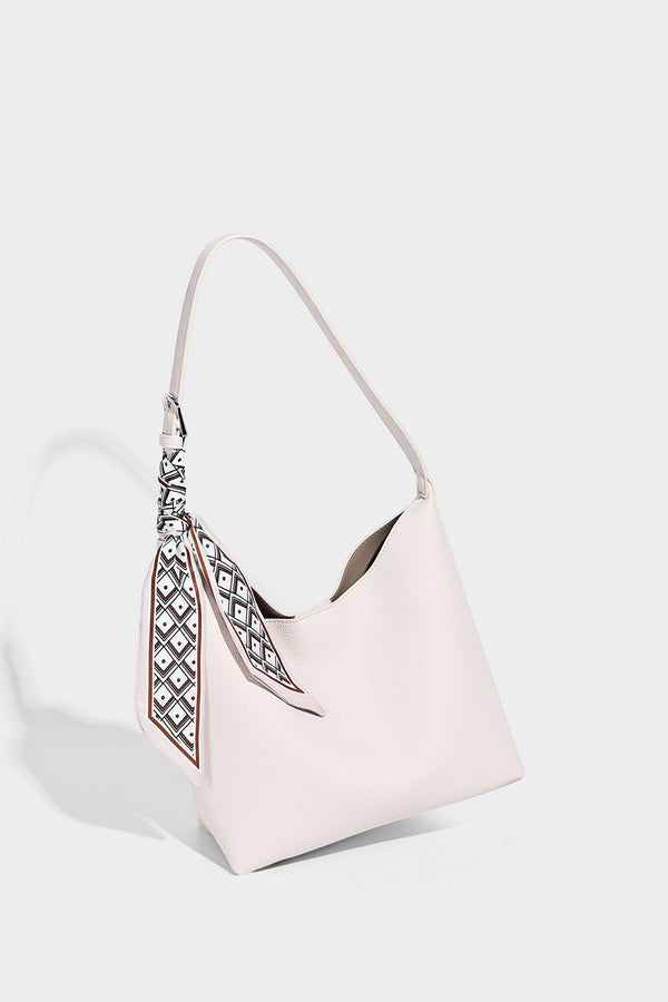 Soft slouchy hobo shoulder bag in pebbled matte finish with slim strap, silver-tone ring hardware, and knotted printed scarf