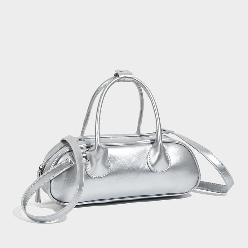 Kompakte silberfarbene Mini-Boston-Tasche mit zwei Tragegriffen oben, silberfarbenen Metallelementen und abnehmbarem Crossbody-Riemen, Detailansicht