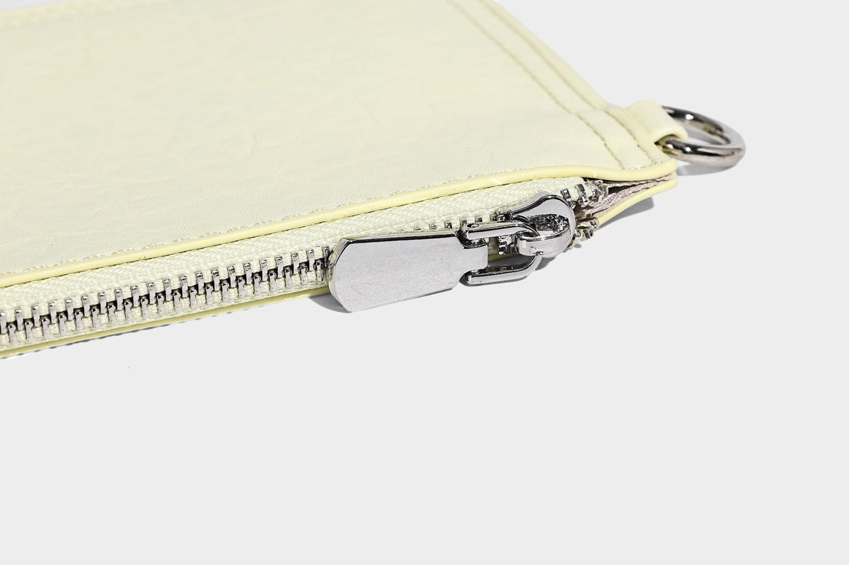 Slouchy hobo shoulder bag in pale yellow glossy pebbled leather-look finish with single shoulder strap and detachable front