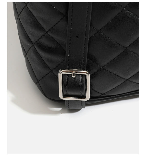 Black diamond-quilted backpack handbag with silver-tone chain flap accent and adjustable shoulder straps, detail view 20