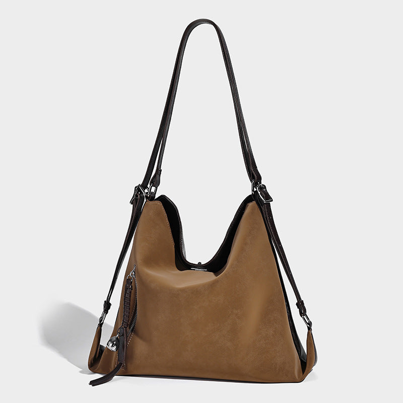 Slouchy hobo tote bag with matte leather-look finish, triangular silhouette, front zip pocket, and adjustable shoulder strap