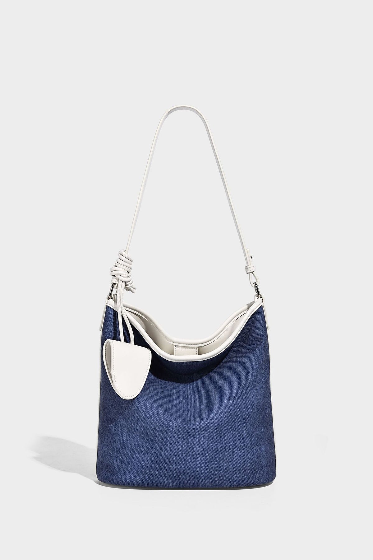 Große Bucket-Schultertasche aus Canvas in Denim-Optik mit Besatz in weißer Lederoptik, geknotetem Riemen und abnehmbarer Mini-Tasche auf der Vorderseite