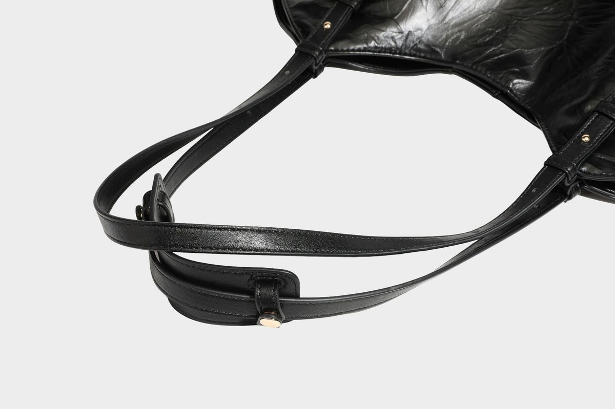 Große, glänzende Tragetasche in Schwarz aus geknitterter Lederoptik mit lässiger Trapez-Silhouette, zwei Schulterriemen und goldfarbenem
