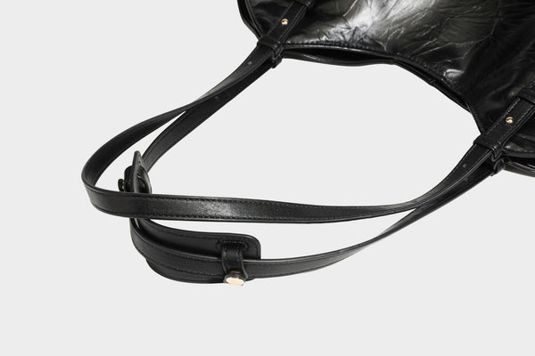 Große, glänzende Tragetasche in Schwarz aus geknitterter Lederoptik mit lässiger Trapez-Silhouette, zwei Schulterriemen und goldfarbenem