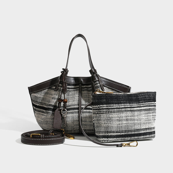 Schwarz-weiße gewebte Trapez-Tote-Bag mit dunkler Verzierung in Lederoptik, weißen Kontrastnähten und zwei Henkeln oben, Detail