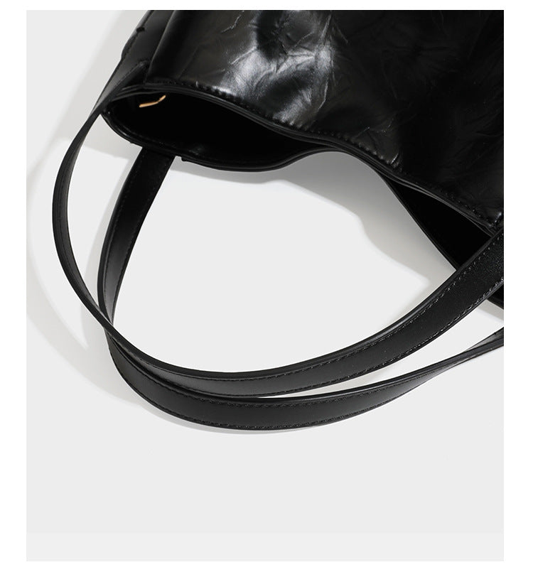 Black glossy crinkled leather-look convertible shoulder tote bag with gold gourd-shaped emblem hardware and detachable