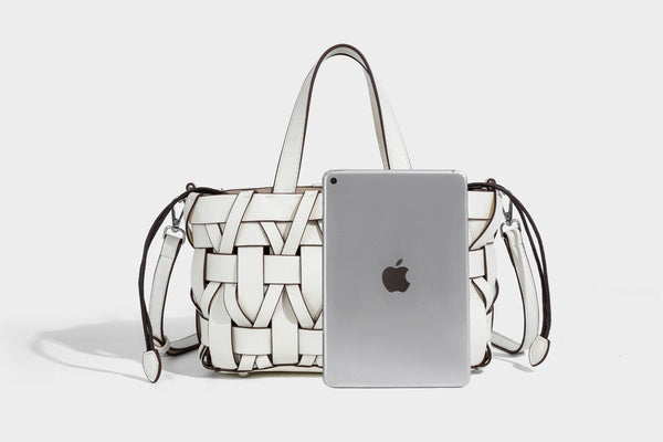 Structured woven basket tote handbag with contrasting dark trim, double top handles, detachable shoulder strap, and