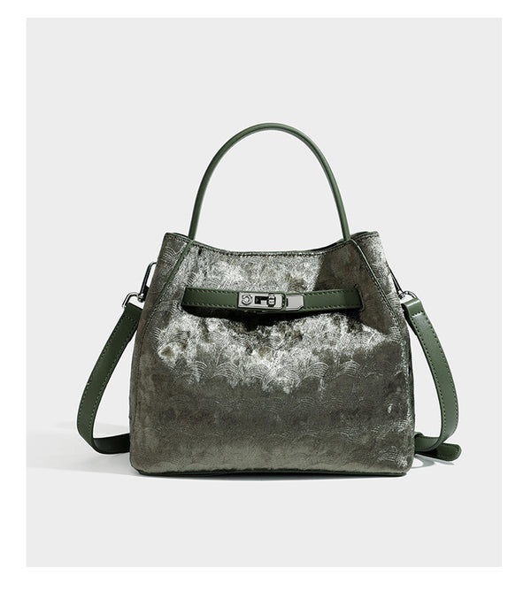 Small structured bucket satchel in embossed velvet-texture fabric with silver turn-lock hardware, rounded top handle, and