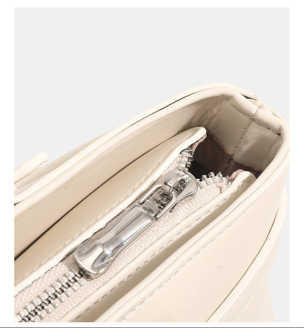 Mini-Trapeztasche mit glatter lederähnlicher Oberfläche, vorderem Riemen mit Dornschließe, zwei Tragegriffen und abnehmbarem, Detailansicht