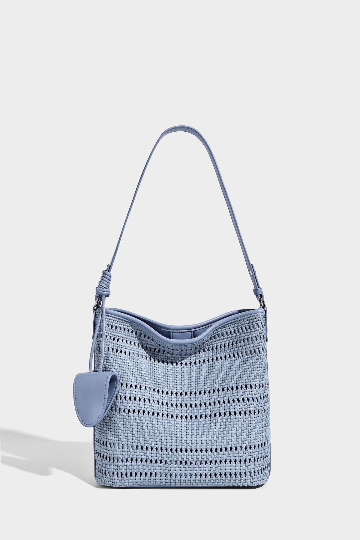 Handwoven open-weave shoulder bag with leather-look trim, knotted adjustable strap, and clip-on sunglasses sleeve pouch