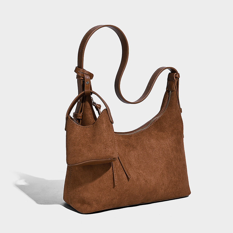 Dark brown suede-look hobo shoulder bag with top zip closure, adjustable strap, and small detachable mini pouch, detail view