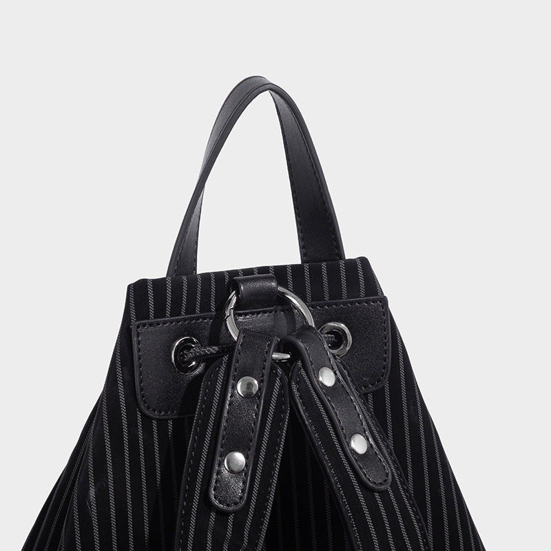 Schwarze wandelbare Rucksack-Handtasche mit Nadelstreifen, Zugbandverschluss, Tragegriff in Lederoptik und matten Beschlägen, Detailansicht
