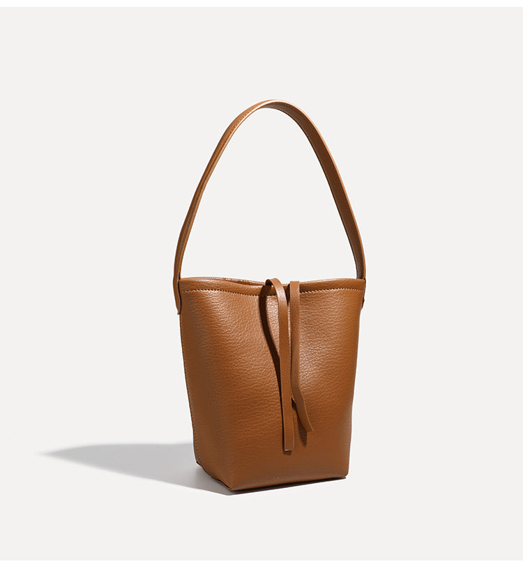 Mini tapered bucket bag in pebbled leather-look finish with front tie straps and single shoulder strap, detail view 19