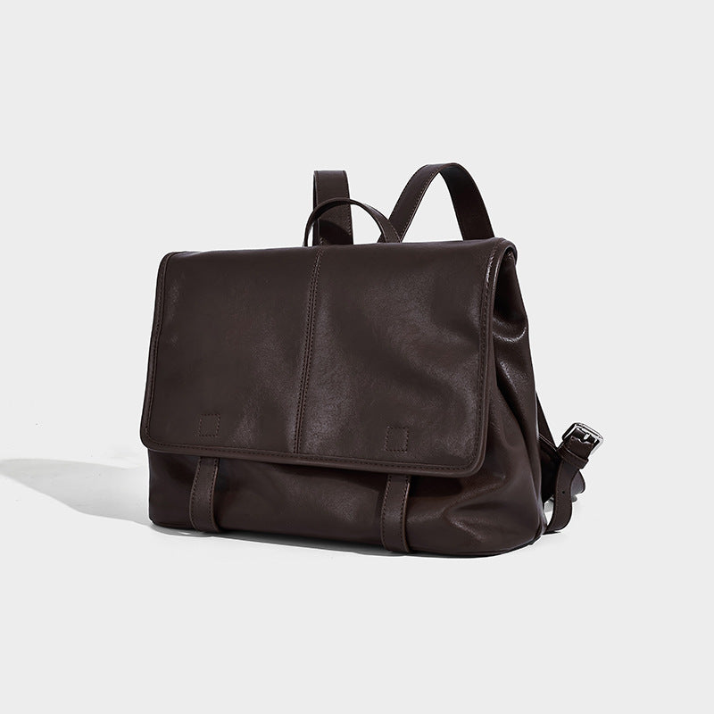 Structured tan leather-look flap backpack handbag with top handle, silver buckle hardware, and fold-over front closure