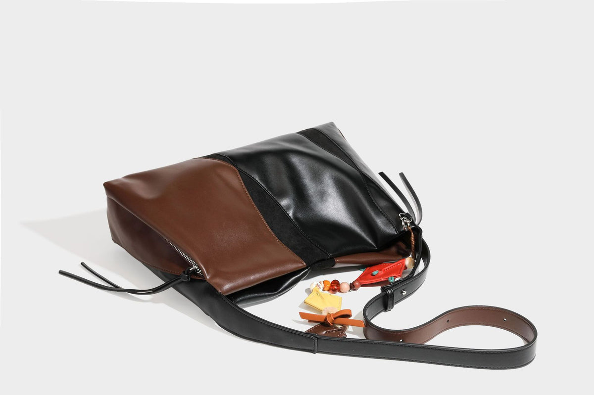 Two-tone black and brown leather-look slouchy shoulder bag with beaded tassel charm and silver-tone hardware, detail view 32
