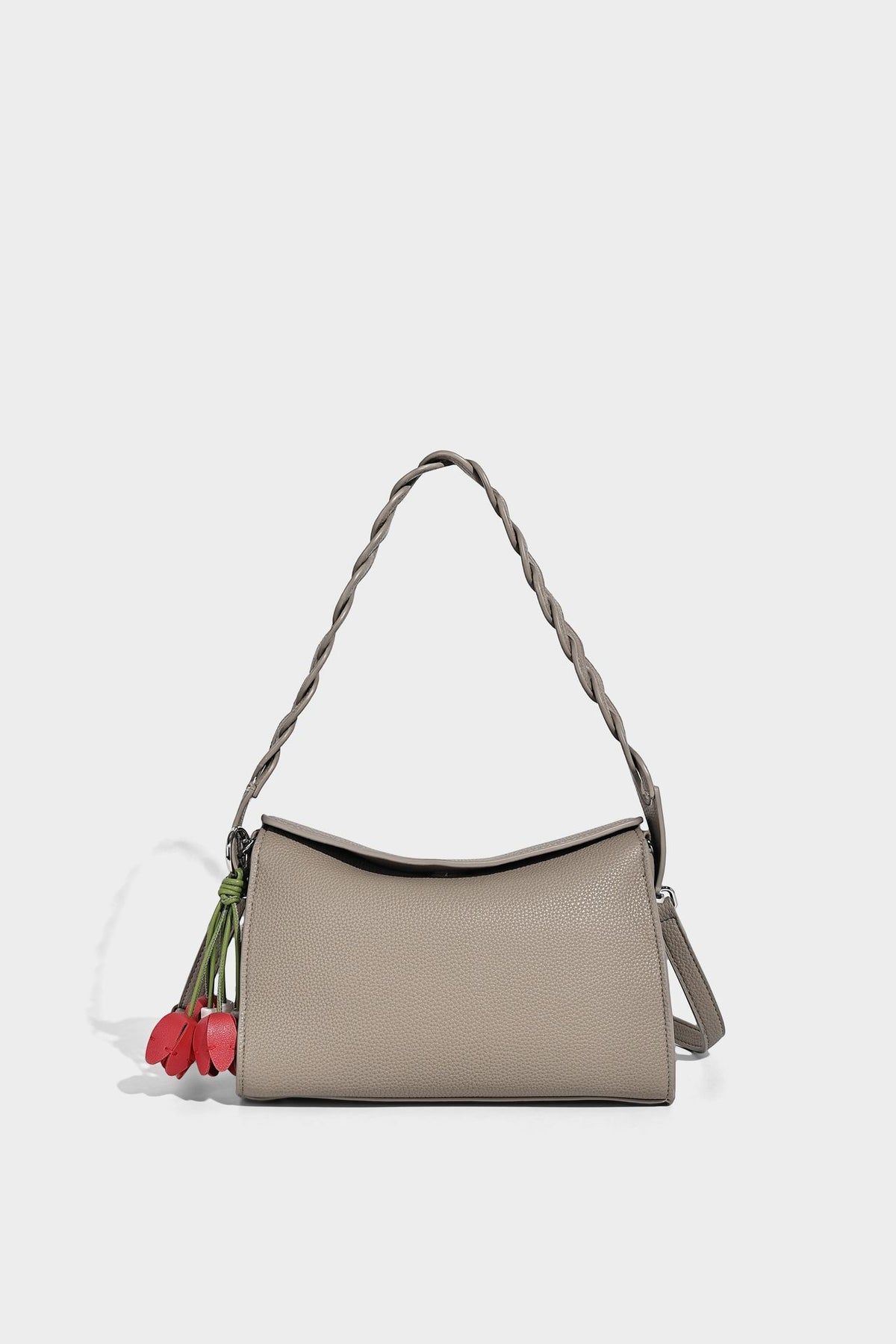 Small structured pebbled-finish shoulder bag with braided top handle, detachable crossbody strap, floral tassel charm, and