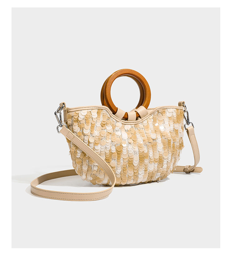 Small sequin half-moon handbag with circular wood-look ring handles and detachable leather-look shoulder strap, detail view