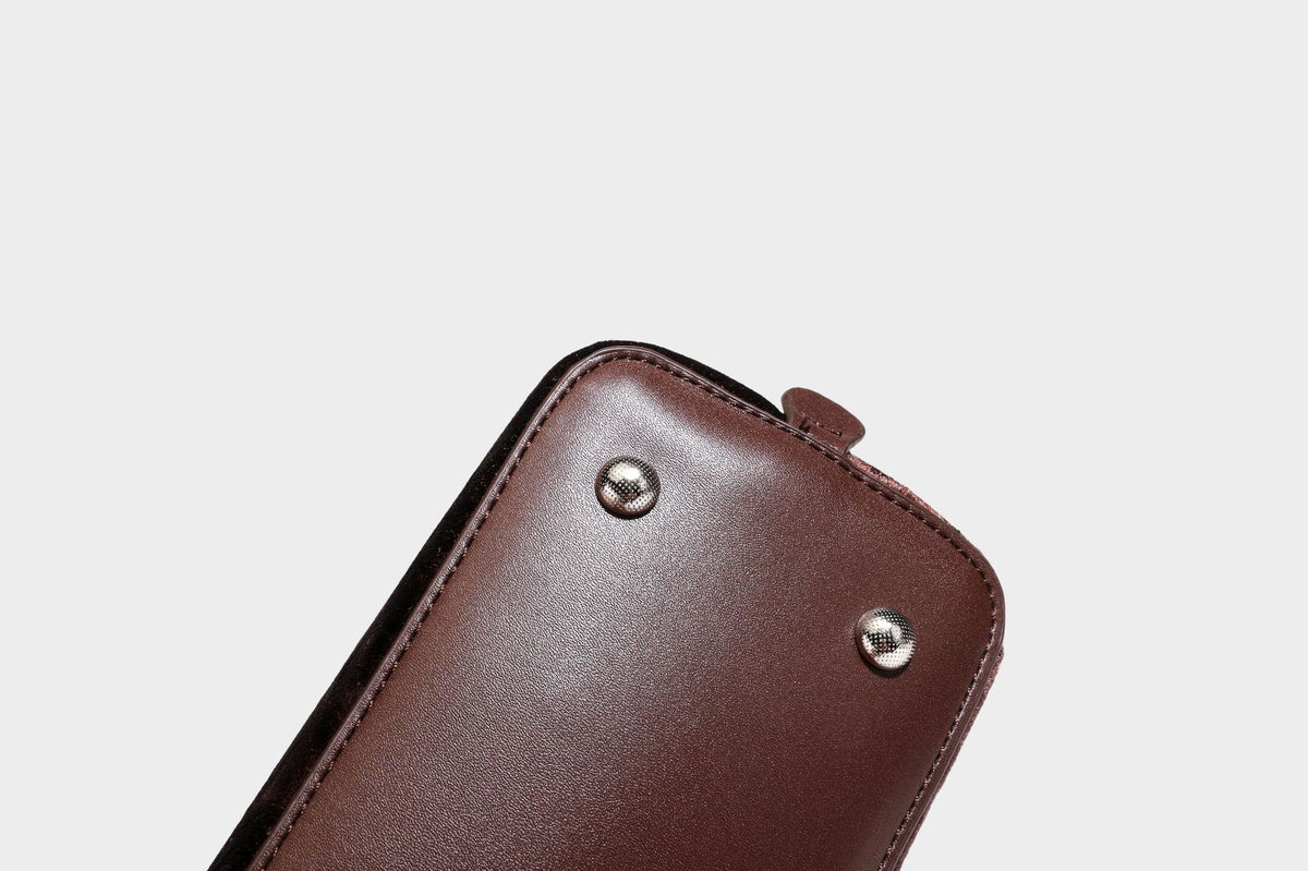 Small structured satchel bag in dark brown velvet-like textured finish with leather-look trim, silver-tone turn-lock bar