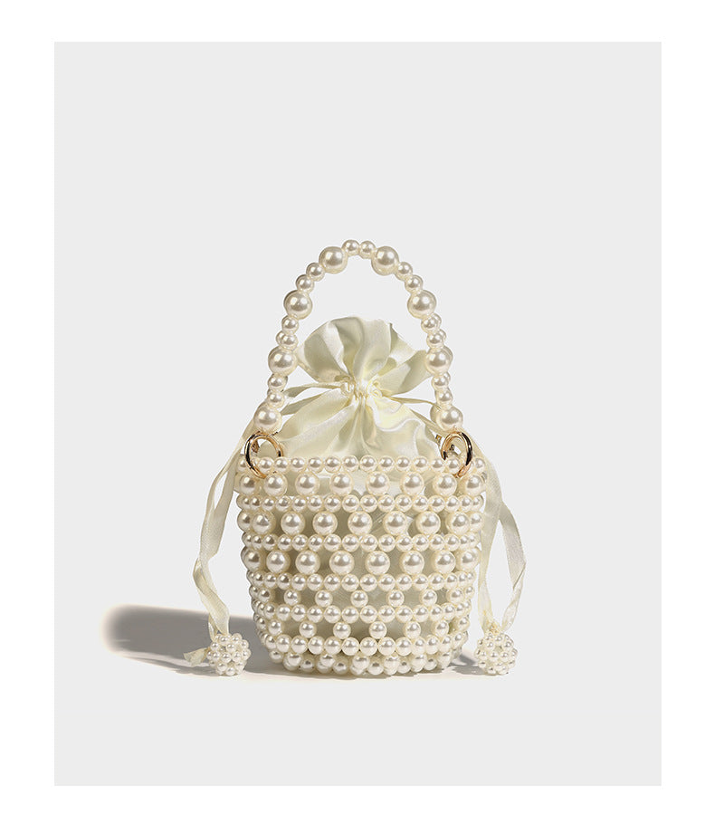 Elfenbeinfarbene Mini-Bucket-Bag aus Kunstperlen mit Satin-Innenbereich und Zugband, goldfarbenen Ringbeschlägen und gewölbtem Perlenhenkel an der Oberseite