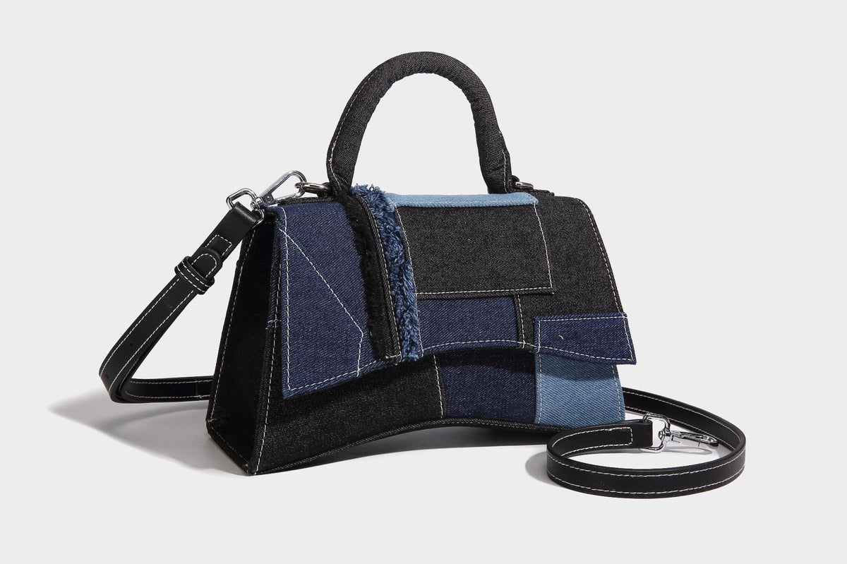 Structured patchwork denim trapezoid satchel bag with frayed panel trim, rounded top handle, and silver-tone hardware, detail